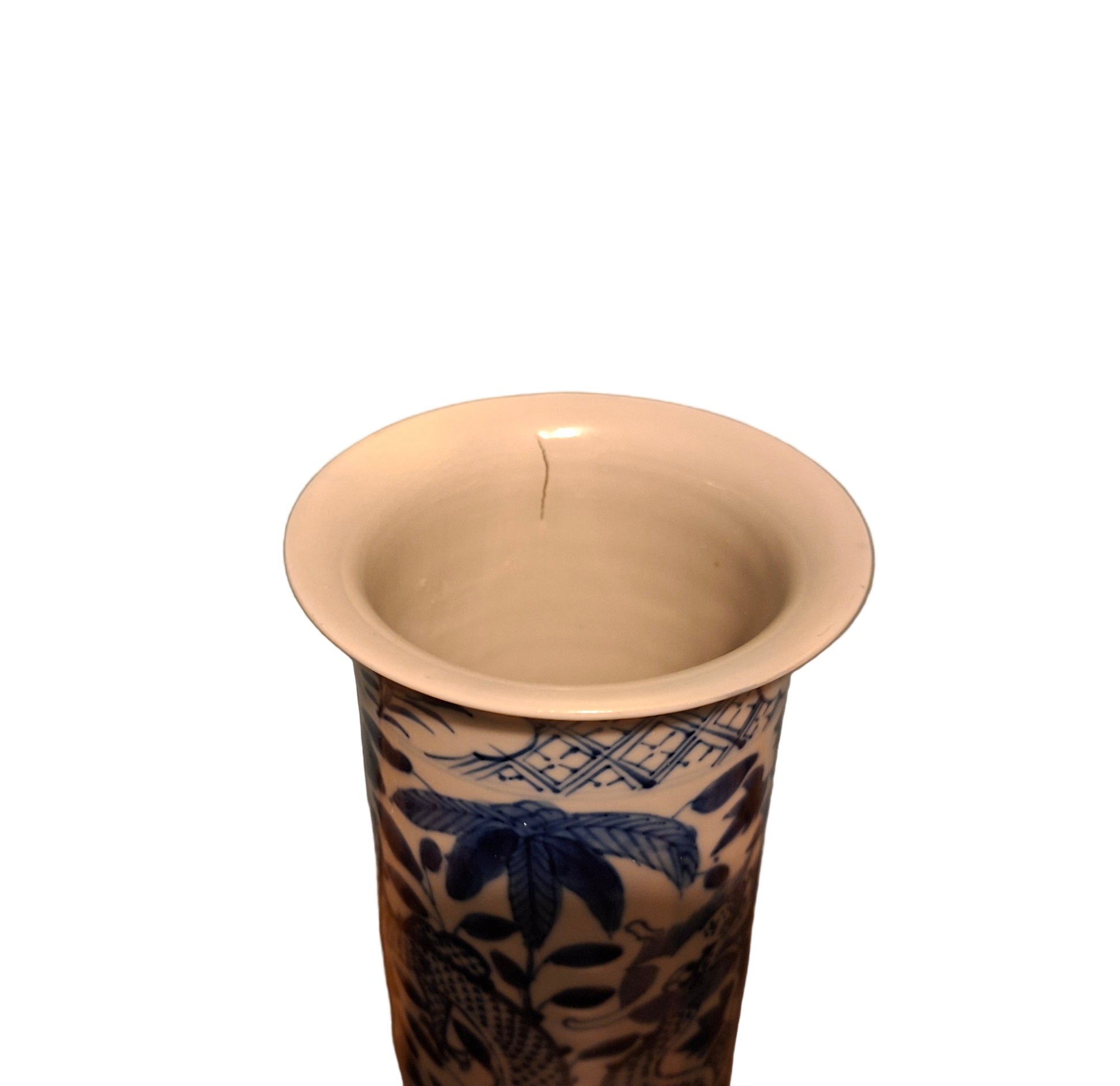 Chinese Antique Brush Pot with blue and white floral patterns on a wooden surface against a gray wall