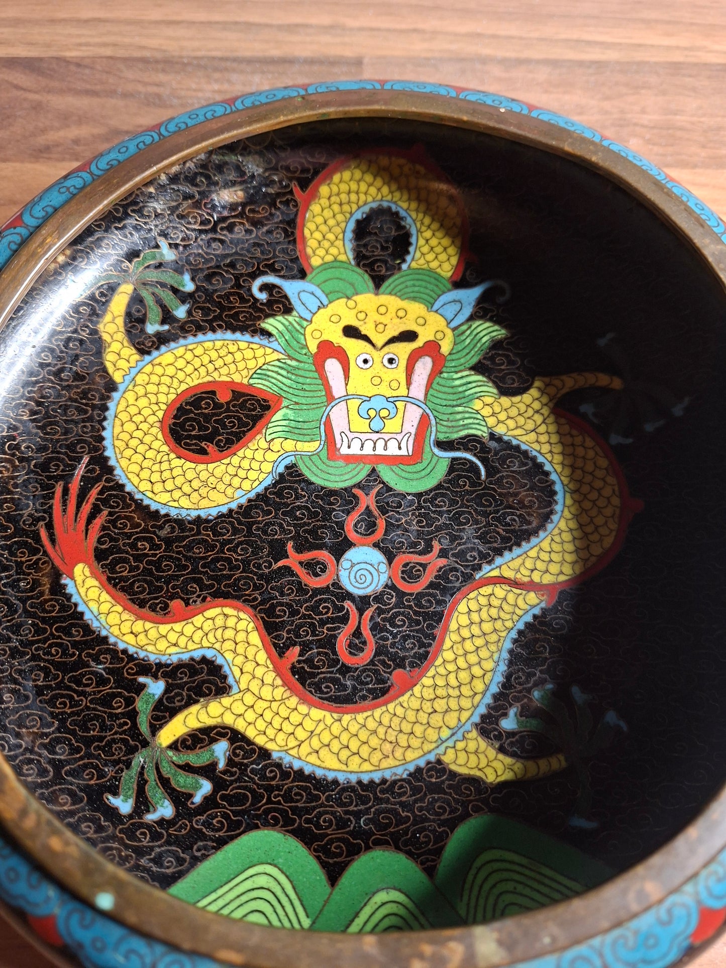 A stunning Chinese cloisonne low brass bowl with a dynamic dragon motif