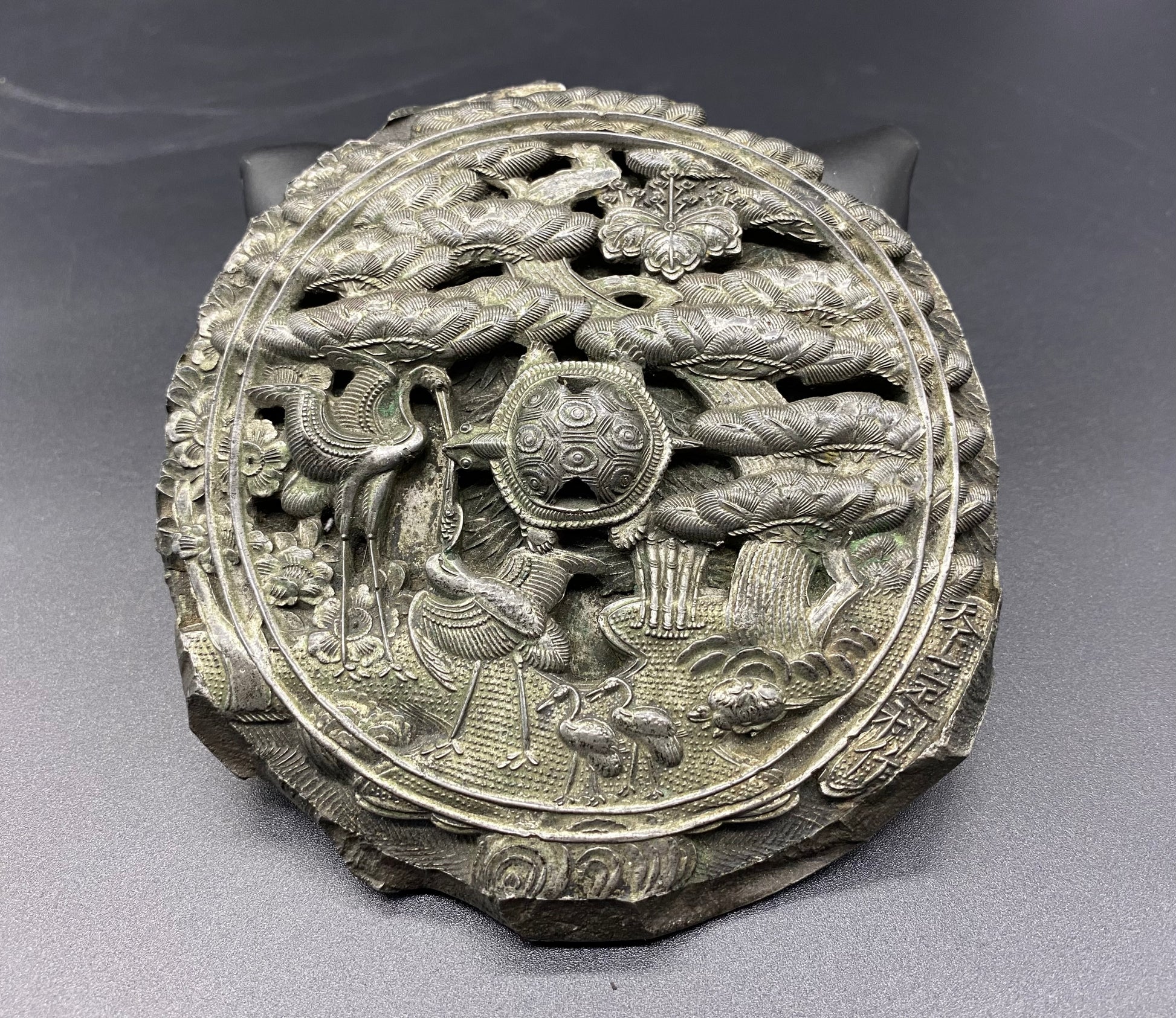 A heavy and finely cast Japanese bronze mirror with longevity symbols, Edo Period, 18th century, Japan. The round mirror has been intricately and exquisitely cast with symbols of longevity.