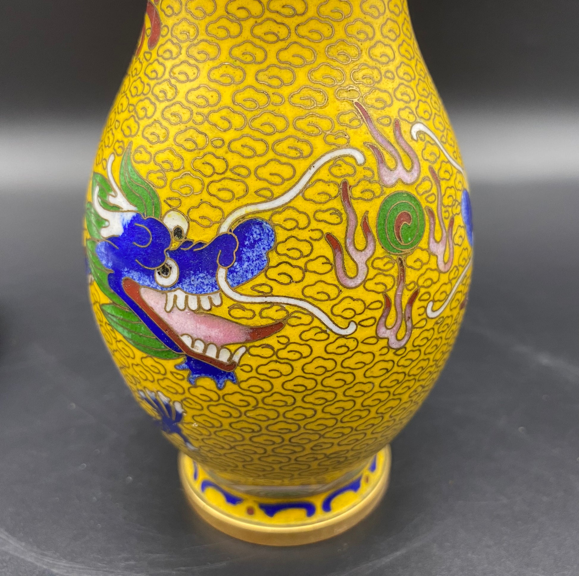 Fine heavy antique Chinese cloisonne lidded vase with golden decorated cells on a black background with flowers, buds and butterflies in hues of pinks greens and purples, with golden accents.