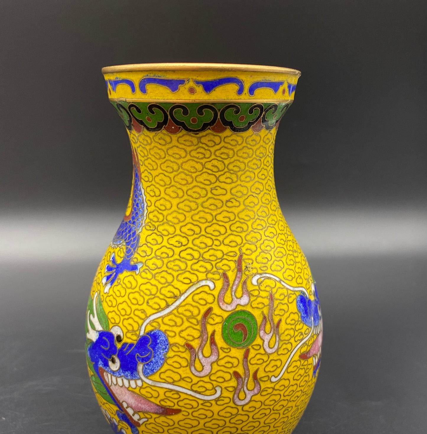 The inside and underside of the vase is finished in a rich turquoise enamel. The vase comes on an intricately carved wooden lacquered stand, and measures 19cm tall - 24cm on its stand and is 14cm wide.