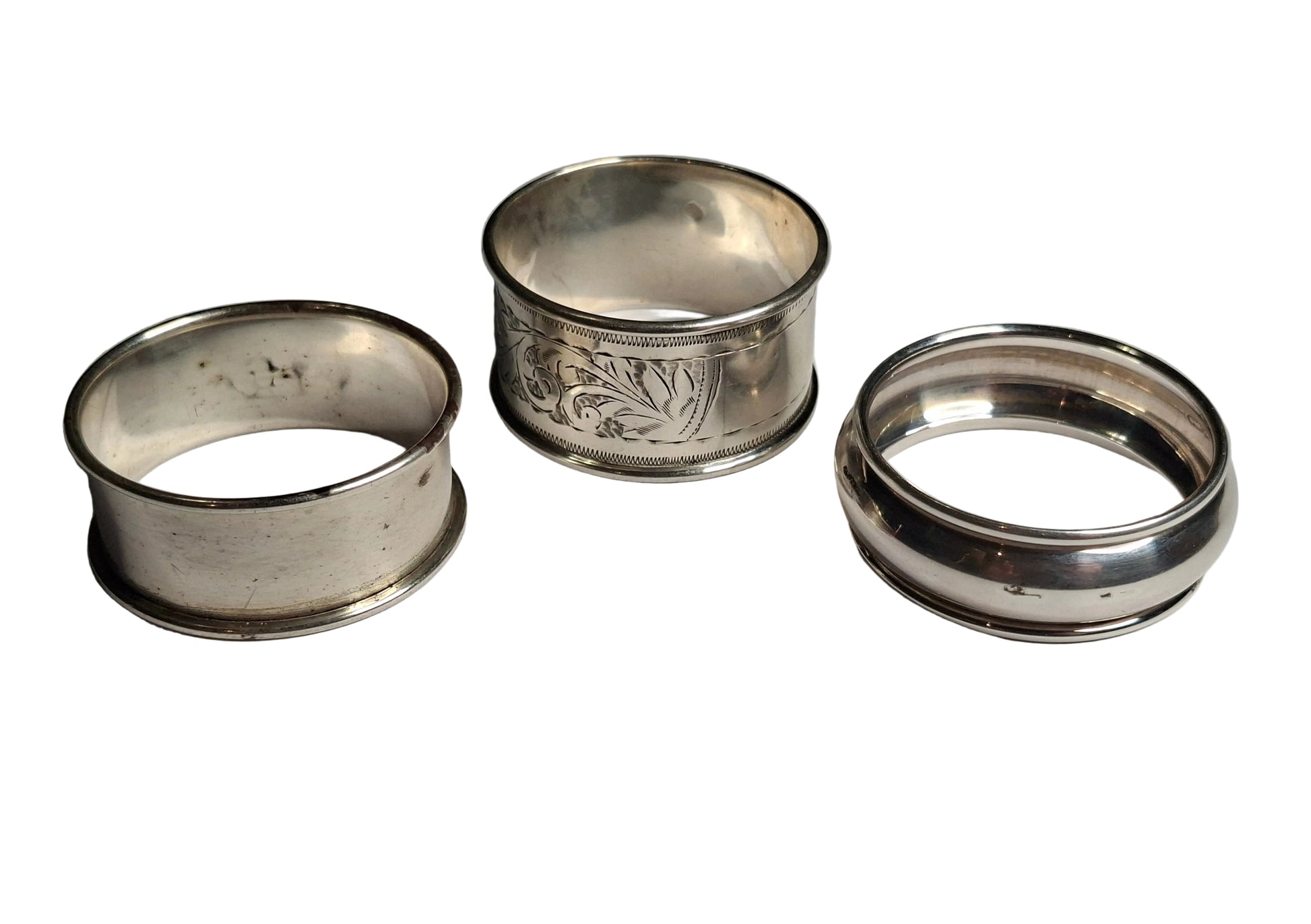 set of antique solid silver napkin rings, including examples hallmarked Birmingham 1911 and Chester 1913, along with a third piece with rubbed hallmarks.