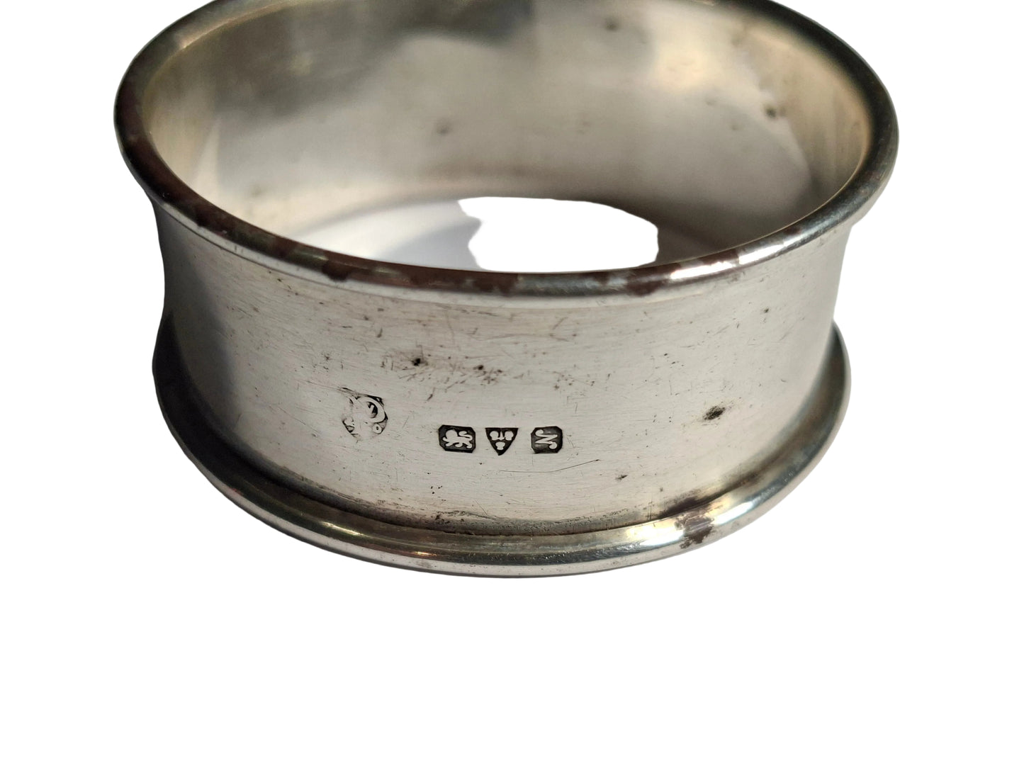 set of three antique silver napkin rings, including rare examples hallmarked Birmingham 1911 and Chester 1913, along with a third piece with rubbed hallmarks.