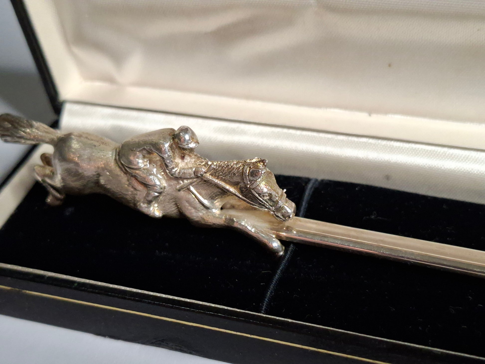 close up view of a vintage Irish silver letter opener with an equestrian figure mount.