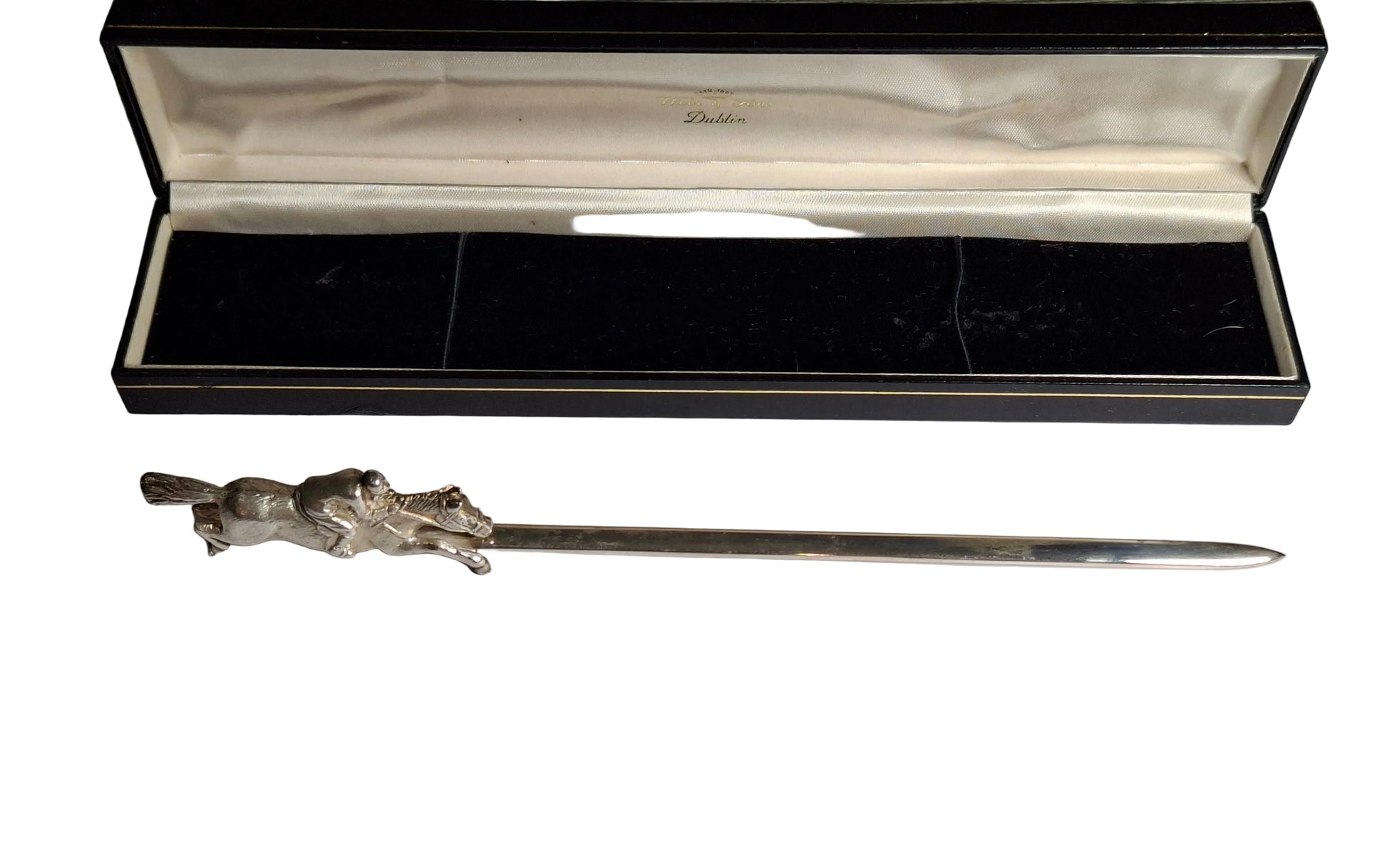 Silver letter opener with decorative handle on a white surface, accompanied by a card and in front of an open black box.