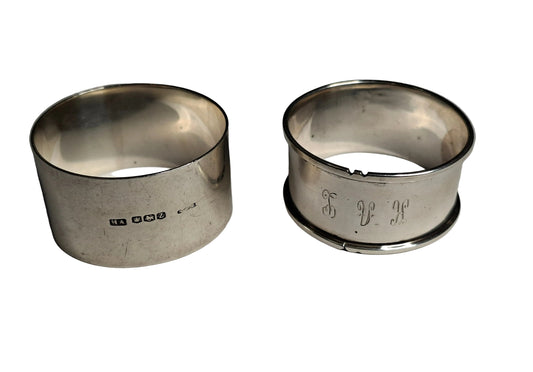 A pair of antique sterling silver napkin rings, showcasing English craftsmanship from two notable periods. The first is hallmarked Sheffield, 1942, weighing 30 grams