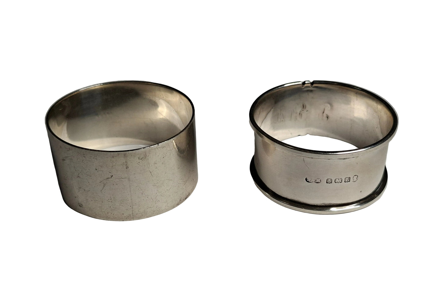 A pair of antique silver napkin rings, showcasing English craftsmanship from two notable periods. The first is hallmarked Sheffield, 1942, weighing 30 grams