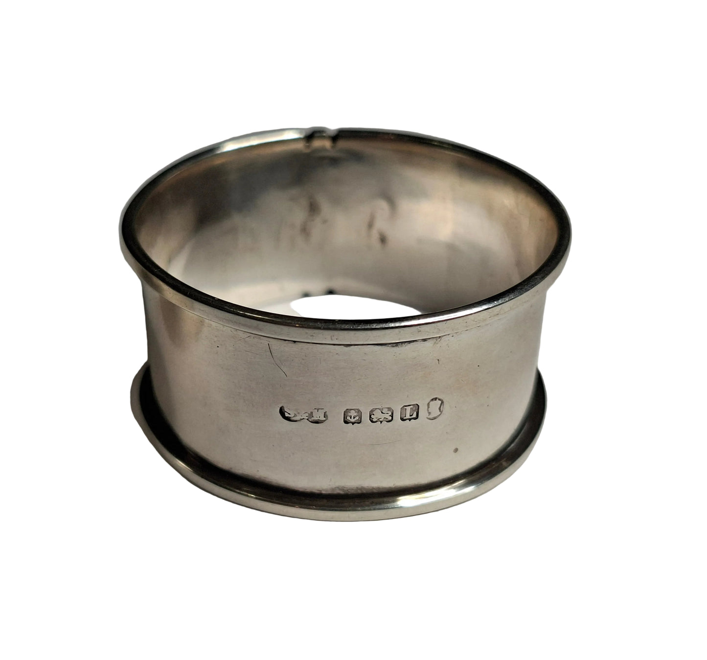 A pair of antique solid silver napkin rings, showcasing English craftsmanship from two notable periods. The first is hallmarked Sheffield, 1942, weighing 30 grams